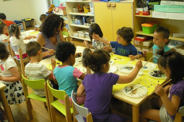 Una insegnante con dei bambini che disegnano