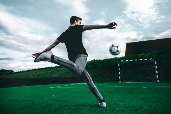 Giovane ragazzo da un calcio ad un pallone